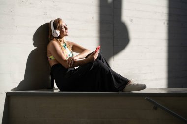 Sıradan kıyafetler giyen akıllı telefon kullanan bir kız.