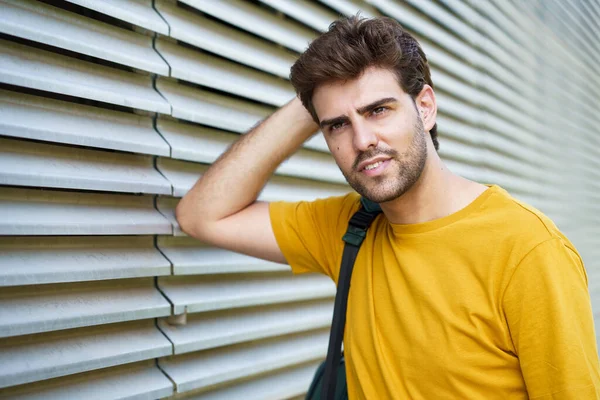 Jeune homme avec une coupe de cheveux moderne en fond urbain — Photo