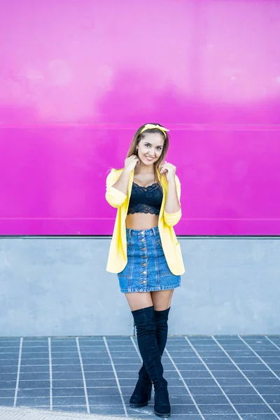 Jonge vrouw met een geel jasje en een hoofdband — Stockfoto