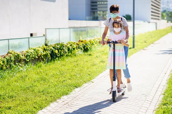 Мати і дочка катаються на електричному скутері . — стокове фото