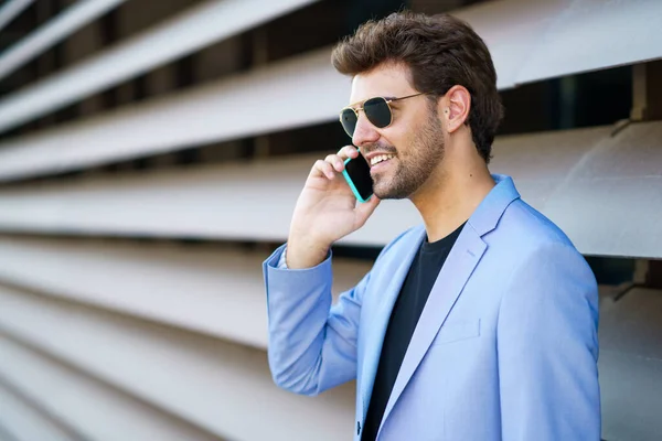 Adam mutlu bir ifadeyle akıllı telefonuyla konuşuyor. — Stok fotoğraf