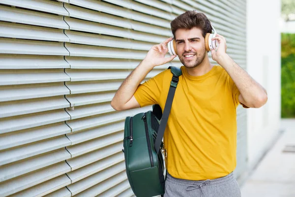 Jovem com fones de ouvido em fundo urbano — Fotografia de Stock