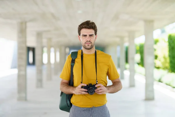 Homme millénaire prenant des photos avec un appareil photo reflex — Photo