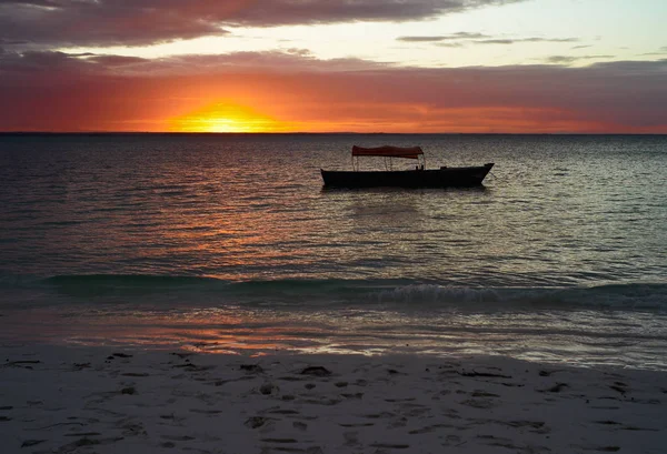 Sundown on the Beach with the Silhouette of a Small Fishing Boat at Michamvi Beach, Zanzibar