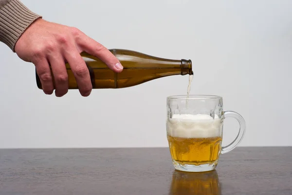 Filling a Dimpled Pint Glass of Beer from the Bottle