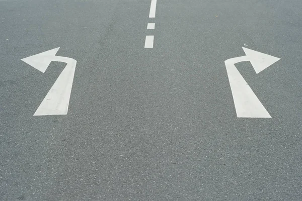 Arrows to the Right and Left on an Asphalt Road - A Concept for Decisions - Turning Left or Right