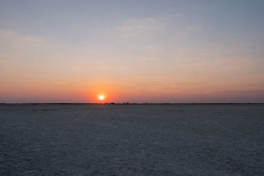Sun Setting in Makgadikgadi Salt Pan - Empty Flat Plain and Hori clipart
