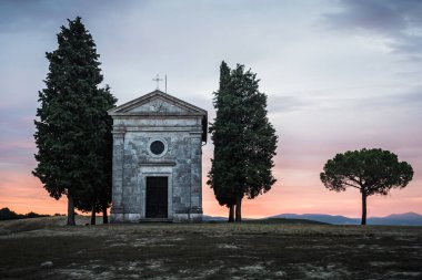 Chapel Capella della Madonna di Vitaleta in Val d 'Orcia, Tuscany, Italy at Sunrise or Dawn in the Romantic and Mysterious First Light with Cypress Trees