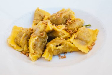 Tortelli di Zucca alla Mantovana Mantua, Lombardy, İtalya 'dan Bilge Tereyağı ve Amaretti Kırıntıları ile Beyaz Tabakta