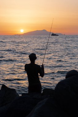 Sorrentine kıyısındaki balıkçı ya da balıkçı ya da balıkçı ya da gün batımındaki yarımada. Ischia 'nın karşısında, Dusk' ta.