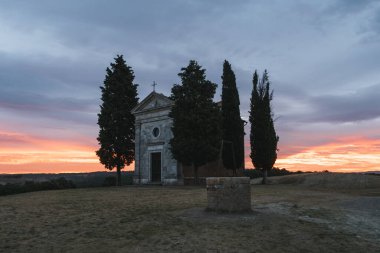 Chapel Capella della Madonna di Vitaleta in Val d 'Orcia, Tuscany, Italy at Sunrise or Dawn in the Romantic and Mysterious First Light with Cypress Trees