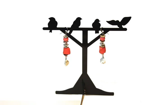 El yapımı takı - küpe yapılan beyaz ve pembe mercan bir stand. Beyaz arka plan. Hobiler ve yaratıcılık.