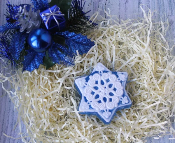 El yapımı sabun kar taneleri ve hafif bir arka plan üzerinde mavi Noel süsleri şeklinde. Noel top, hediye ve kozalaklı şube. Mutlu Noeller ve mutlu yeni yıl!
