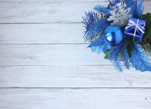Hafif bir arka plan üzerinde mavi Noel süsleri. Noel top, hediye ve kozalaklı şube. Mutlu Noeller ve mutlu yeni yıl!