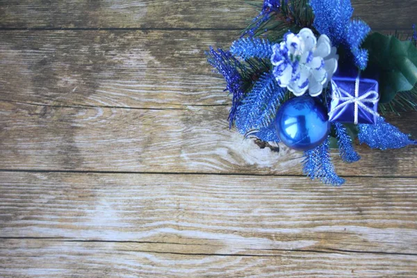 Karanlık bir arka plan üzerinde mavi Noel süsleri. Noel top, hediye ve kozalaklı şube. Mutlu Noeller ve mutlu yeni yıl!