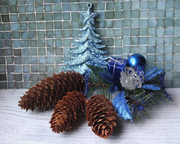 Yılbaşı süsleri ve kozalaklı koni üzerinde bir açık mavi renkli. Mutlu Noeller ve mutlu yeni yıl!