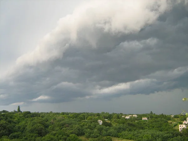 Köyün içinde fırtına bulutları. Fırtınadan önce sakin ol. Yaz günü.