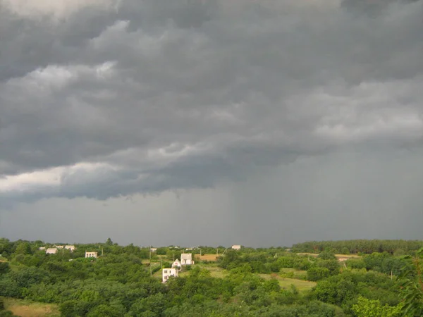 Köyün içinde fırtına bulutları. Fırtınadan önce sakin ol. Yaz günü.