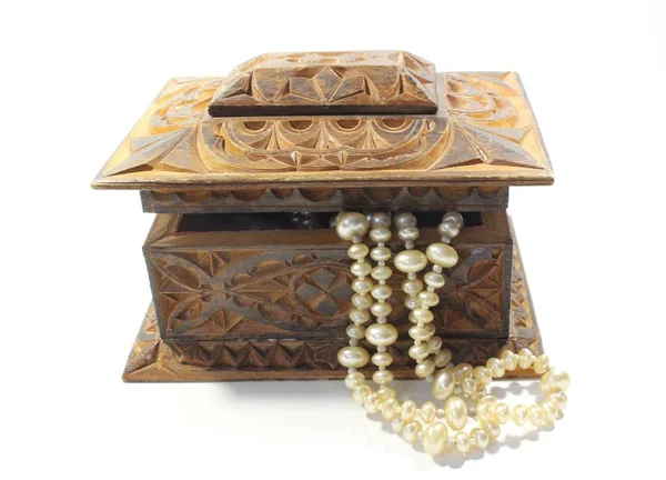Doğal yarı değerli taşlardan yapılmış süs eşyaları ile ahşap dikdörtgen kutu. İşlemeli. Beyaz İncili kolye.
