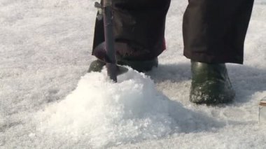 Anglers bir soğuk kış gününde buz kaplı nehirdeki balık yakalamak