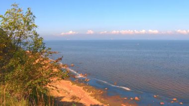 Sonsuz deniz suları üzerinde mavi sabah gökyüzünde küçük beyaz bulutlar