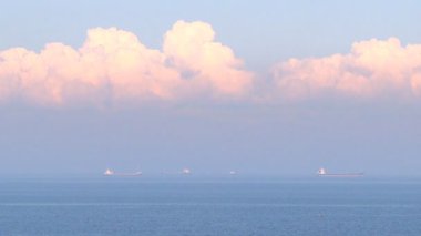 Sonsuz deniz suları üzerinde mavi sabah gökyüzünde küçük beyaz bulutlar