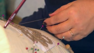 Köy craftswoman ince ipek parçacıklarından güzel dantel modeli döndürme.