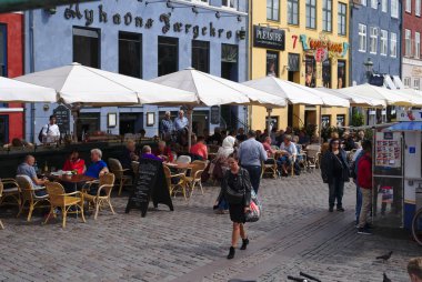 Kopenhag/Danimarka - 24 Ağustos 2018: Nyhavn Kopenhag, Danimarka waterfront semtinde olduğunu. İnsanlar burada yemek yemek emretmek için ve içme onların arkadaşları ve aile ile geliyor bu yüzden güneşli bir gün bugündür.