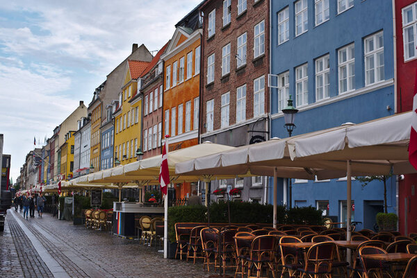Copenhagen/Denmark - August 24 2018 : Nyhavn is a waterfront district in Copenhagen, Denmark. Today is a sunny day so people come here to enjoin eating food and drinking with their friends and family.