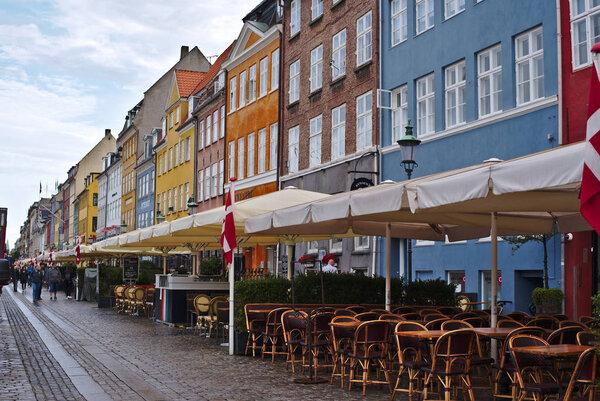Copenhagen/Denmark - August 24 2018 : Nyhavn is a waterfront district in Copenhagen, Denmark. Today is a sunny day so people come here to enjoin eating food and drinking with their friends and family.