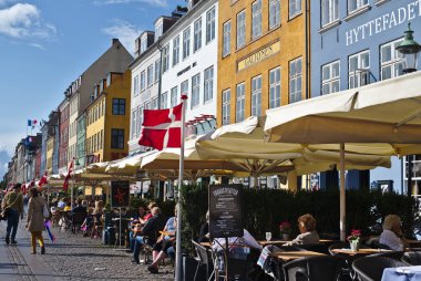 Kopenhag/Danimarka - 24 Ağustos 2018: Nyhavn Kopenhag, Danimarka waterfront semtinde olduğunu. İnsanlar burada yemek yemek emretmek için ve içme onların arkadaşları ve aile ile geliyor bu yüzden güneşli bir gün bugündür.