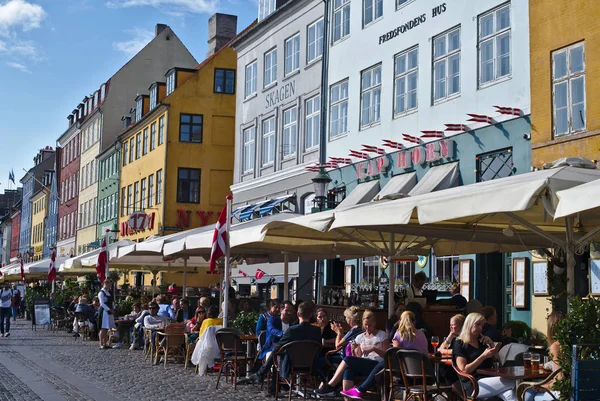 Kopenhag/Danimarka - 24 Ağustos 2018: Nyhavn Kopenhag, Danimarka waterfront semtinde olduğunu. İnsanlar burada yemek yemek emretmek için ve içme onların arkadaşları ve aile ile geliyor bu yüzden güneşli bir gün bugündür.