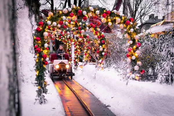 Kopenhag/Danimarka - 9 Aralık 2018: Tivoli Bahçe Kopenhag'da Aralık, park sırasında ışık ve renk dolu ile dekore edilmiştir. Oyuncak tren oturan bir kız parkta Festivali oturanlarla.