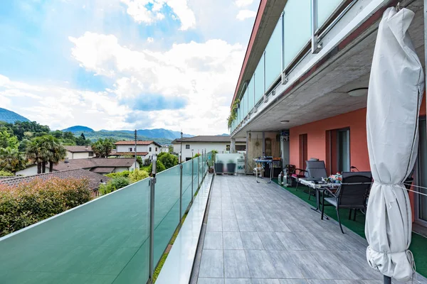 Red building exterior with large terrace and glass parapet. Nobody inside