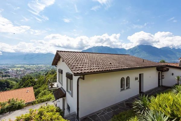 Exterior of villa with large square, view of the Swiss hills. Nobody inside