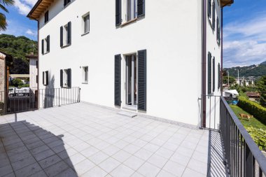 Dış geniş bir teras ile modern beyaz bir ev. İçeride kimse yok