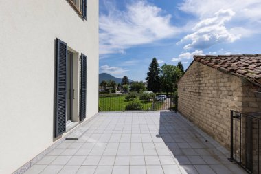 Dış geniş bir teras ile modern beyaz bir ev. İçeride kimse yok