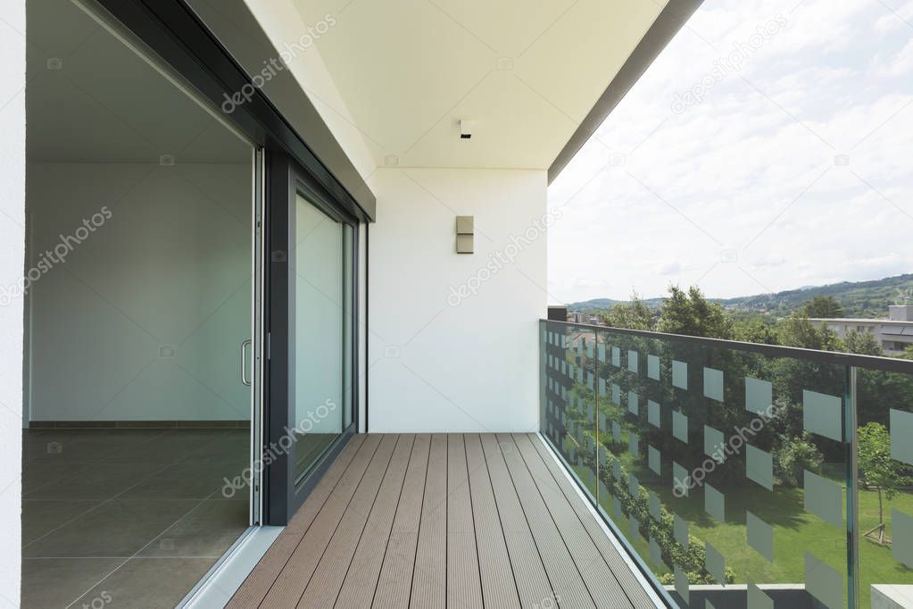 Balcony of modern apartment with white walls, nobody in the scene