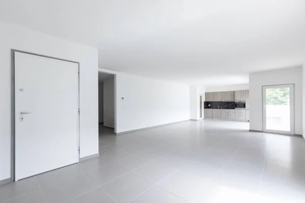宽敞的客厅和完全白色的厨房在一个现代化的开放空间 里面没人 — 图库照片