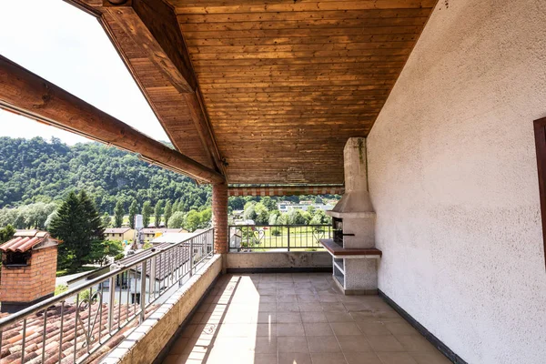 Terrace with wooden ceiling and tiles, landscape and hills. Nobody inside