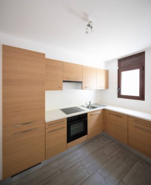 Modern mutfak ahşap ve beyaz duvarlar, küçük bir pencere. İçeride kimse yok