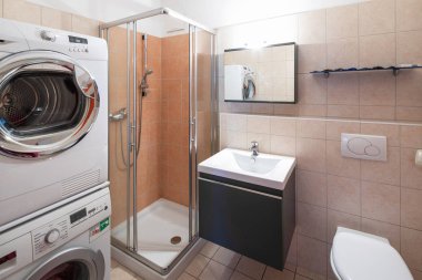Modern banyo fayans, duş, çamaşır makinesi ve kurutma makinesi ile. İçeride kimse yok