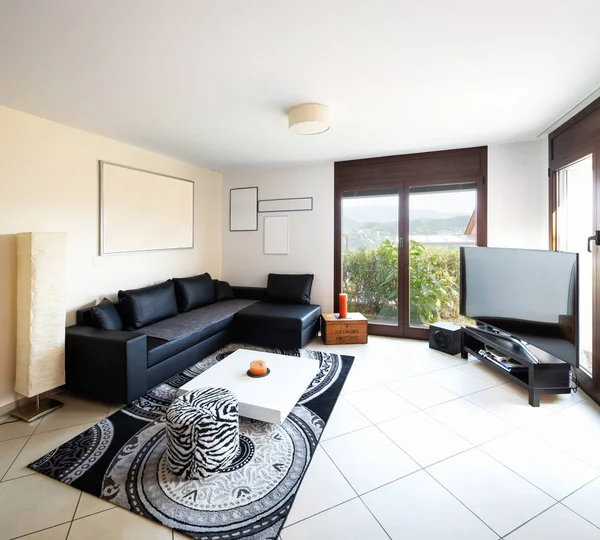 Large living room with large black leather sofa, large screen and fantastic view. Nobody inside