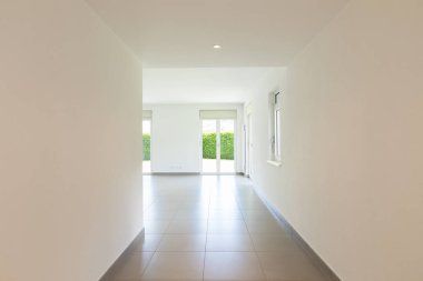 Boş oda pencere ve tamamen beyaz duvar ile. İçeride kimse yok