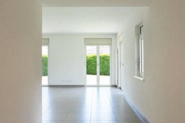 Boş oda pencere ve tamamen beyaz duvar ile. İçeride kimse yok