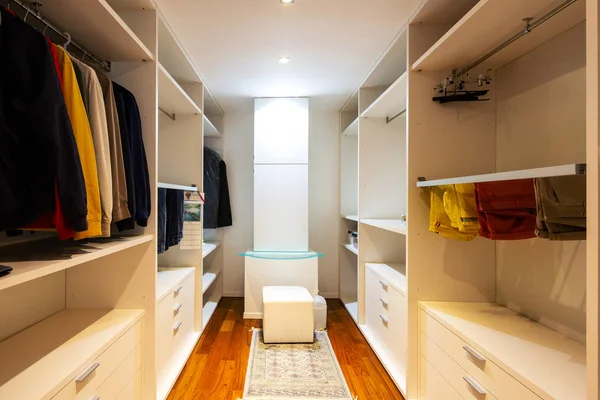 Walk-in closet with only male clothes. Nobody inside