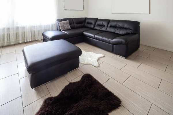 Living room with leather sofa and white walls. Nobody inside