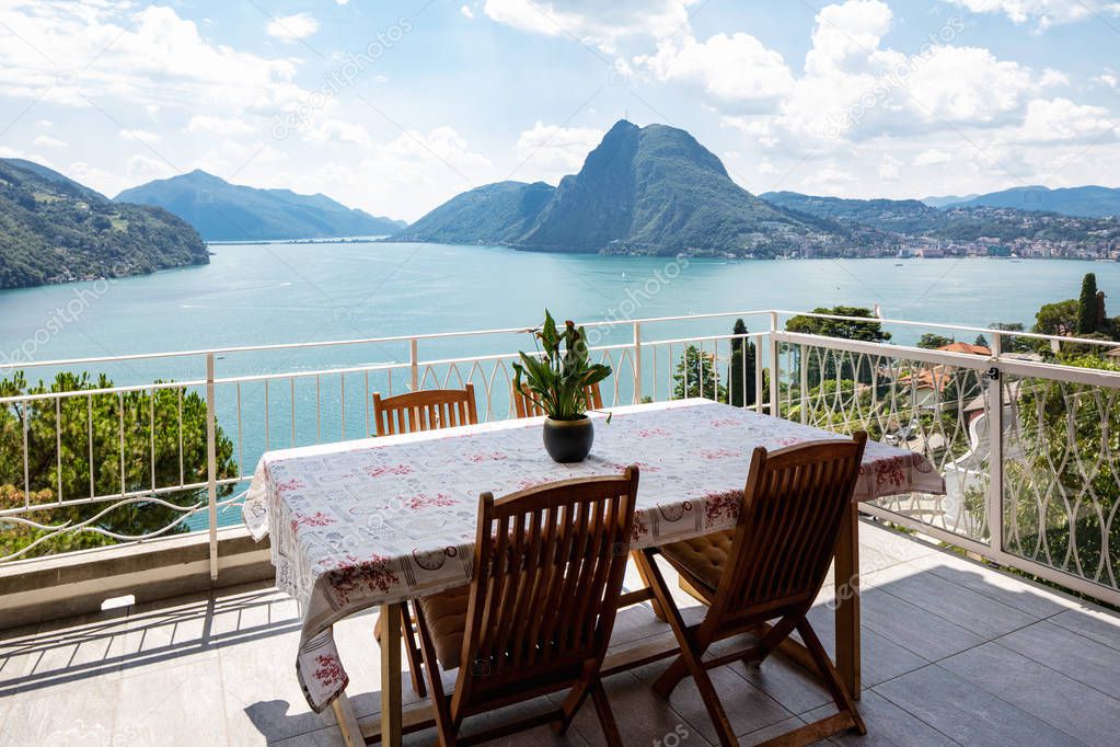 Large terrace overlooking the lake of Lugano on a summer day. Nobody inside