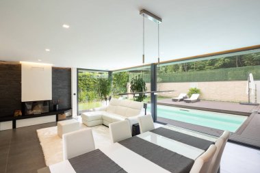 Modern oturma odası Bahçe ve yüzme havuzuna bakan. İçeride kimse yok