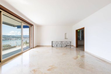 Göle bakan büyük pencereler ile boş oturma odası. İçeride kimse yok